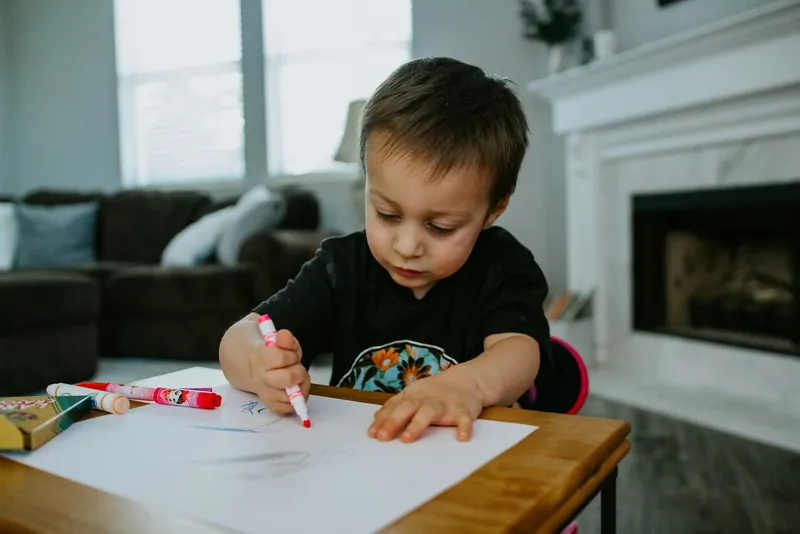 A boy drawing with markers
