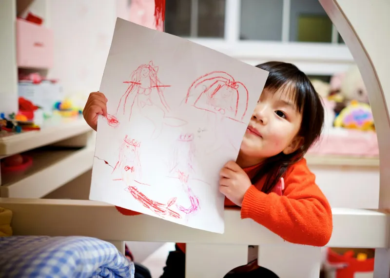 A girl proudly showing her drawing